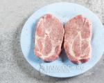 Juicy pork steaks in a frying pan